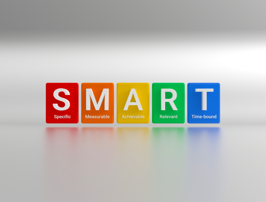 The abbreviation SMART is a strategy for setting goals and objectives. Colored cubes with the abbreviation S.M.A.R.T. - Specific, Measurable, Achievable, Relevant and Time bound. 3D rendering.